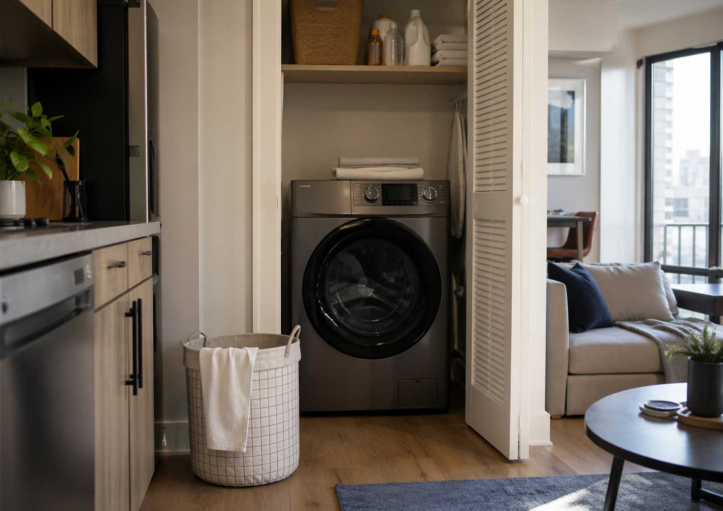 All-in-one washer dryer combo in a compact modern apartment laundry closet next to a living area